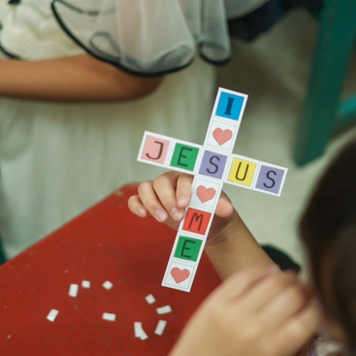 A child holding a paper cross